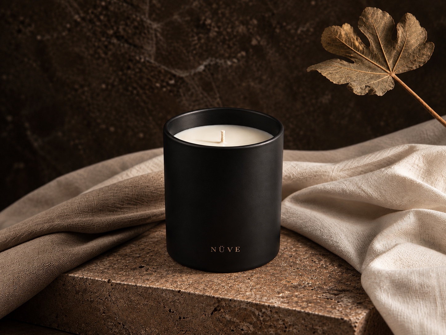 Vela Insignia Negra de NÜVE en vaso negro mate sobre piedra cálida
