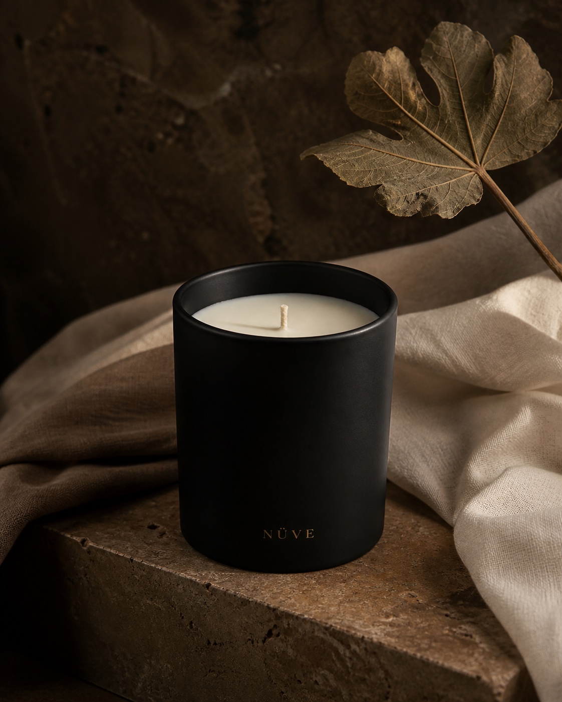 Vela Sombra de Nüve en vaso negro mate sobre piedra cálida